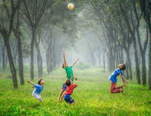 children playing with a ball in a grassy field
