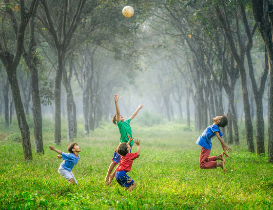 children playing with a ball in a grassy field