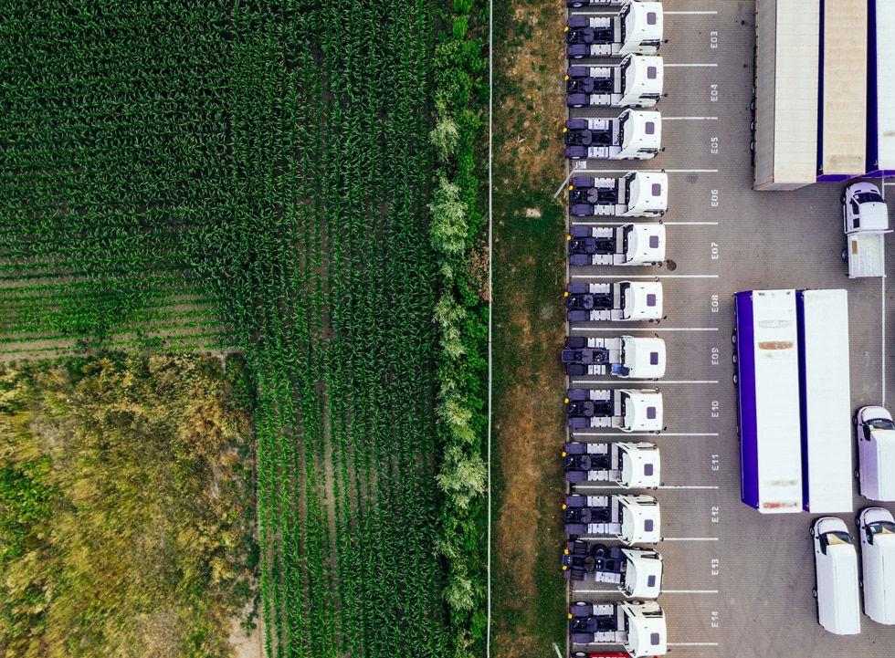 aerial view of crop field and trucks for food transport