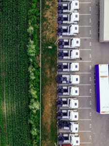 aerial view of crop field and trucks for food transport